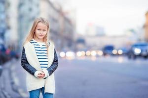 adorable niña de moda al aire libre en una ciudad europea foto
