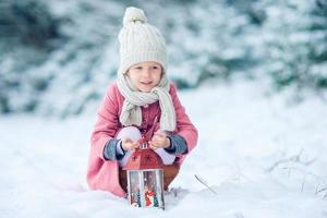 vista trasera de una chica adorable con linterna en Navidad al aire libre foto