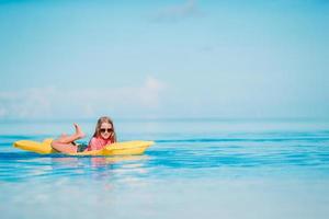 Cute little girl enjoy vacation in the swimming pool photo