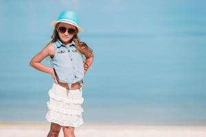 Portrait of adorable little girl at beach during summer vacation photo