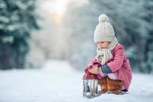 vista trasera de una chica adorable con linterna en Navidad al aire libre foto