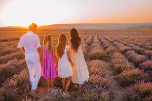 Family in lavender flowers field at sunset in white dress and hat photo