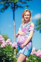 Pregnant woman in outdoor park, warm weather photo