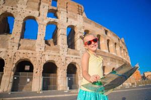 Adorable little active girl with map in front of Colosseum in Rome, Italy. Kid spending childhood in Europe photo