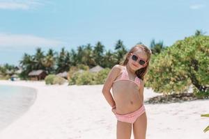 Adorable little girl at beach during summer vacation photo