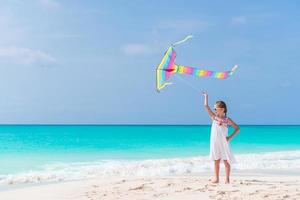 Little girl flying a kite on beach photo
