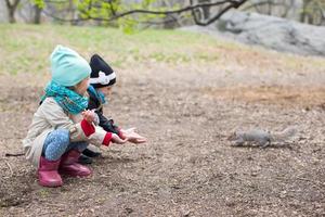 Little girls feeds a squirrel in Central park, New York, America photo