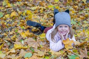Adorable little girl at beautiful autumn day outdoors photo