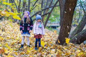 Two adorable girls outdoors in autumn forest photo