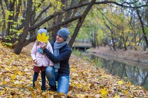 Little girl and happy dad in autumn park outdoors photo