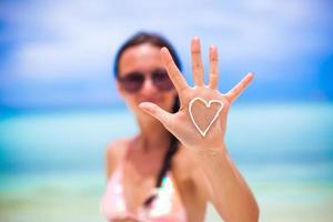 Closeup of girl's hand with heart on the palm painted by suncream photo