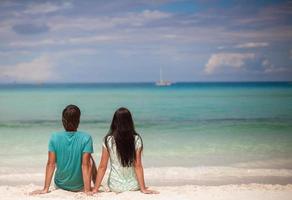 Young couple enjoying each other on sandy white beach photo