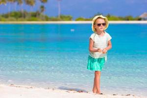 Adorable happy smiling little girl on beach vacation photo