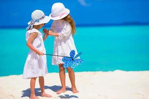 Adorable little girls having fun during beach vacation photo