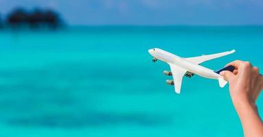 Small white miniature of an airplane on background of turquoise sea photo