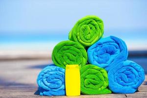 Close up of colorful towels and sunscreen bottle background the sea photo