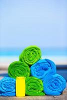 Close up of colorful towels and sunscreen bottle background the sea photo