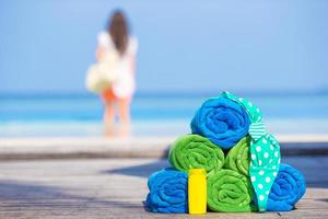 Beach and summer accessories concept - colorful towels, swimsuit and sunsblock background beautiful woman photo