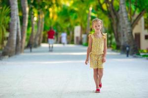 Adorable little girl during beach vacation having fun photo