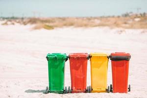 Four plastic containers for garbage sorting on the beach. photo