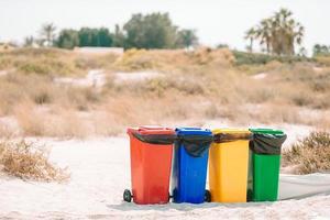 Four plastic containers for garbage sorting on the beach. photo