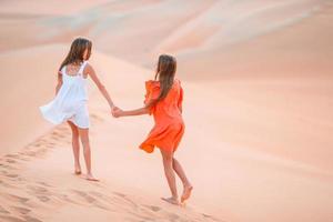 Girls among dunes in big desert in Emirates photo