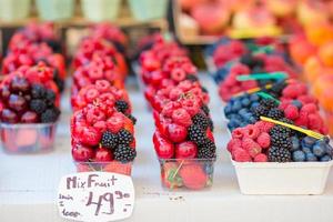 Berry fruits at a marketplace. Blueberries, raspberries, strawberries, cherries and blackberries on the market. Gardening, agriculture, harvest and forest concept. photo