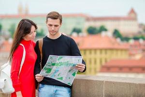 pareja romántica caminando juntos en europa. amantes felices disfrutando del paisaje urbano con monumentos famosos. hombre y mujer urbanos con estilo con mochilas de viaje en praga foto