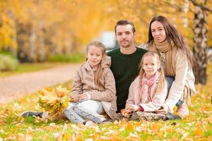 Beautiful happy family of four in autumn day outdoors photo