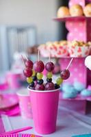 canapé de frutas, pasteles de chocolate blanco y palomitas de maíz en la mesa de los niños dulces en la fiesta de cumpleaños foto