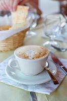 capuchino delicioso y sabroso para el desayuno en el café foto