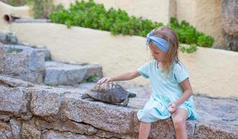 adorable niña feliz con una pequeña tortuga al aire libre foto
