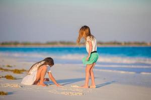 Adorable little kids play together on the beach photo