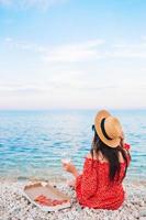 Woman having a picnic with pizza on the beach photo