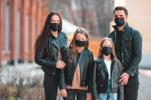 Family wearing a mask on a background of a modern building, photo