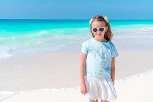 Adorable little girl have fun at tropical beach during vacation photo