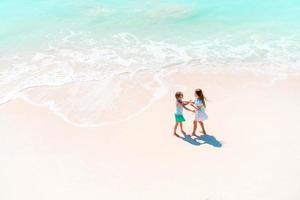 Adorable little girls have a lot of fun on the beach. photo