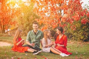 Portrait of happy family of four in autumn day photo