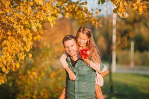 Family of dad and kid on beautiful autumn day in the park photo