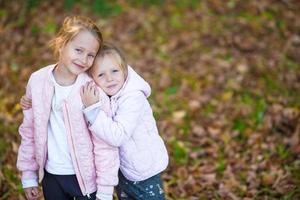 Little adorable girls outdoors at warm autumn day photo