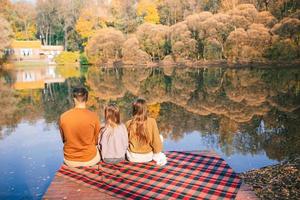 Happy family on a picnic in the park at autumn photo