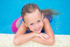Closeup little girl having fun in outdoor swimming pool photo
