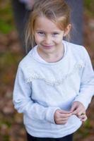 Adorable little girl outdoors at beautiful autumn day photo