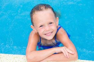 Closeup little beautiful girl in outdoor swimming pool photo