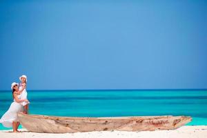 Happy family of mother and little girl on white beach photo