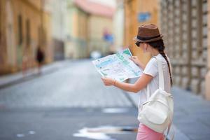 bella mujer mirando el mapa turístico de la ciudad de roma, italia. niña feliz disfruta de vacaciones italianas en europa. foto
