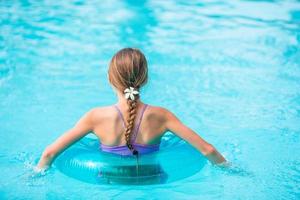 Little adorable girl in outdoor swimming pool photo