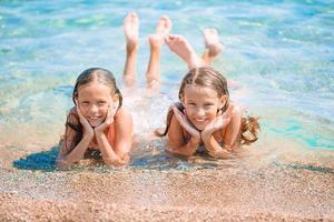 Adorable little girls having fun on the beach photo