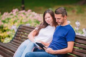 Relaxed young family on the bench in the park photo