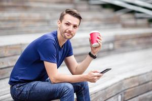 Man is reading text message on mobile phone while walking in the park photo